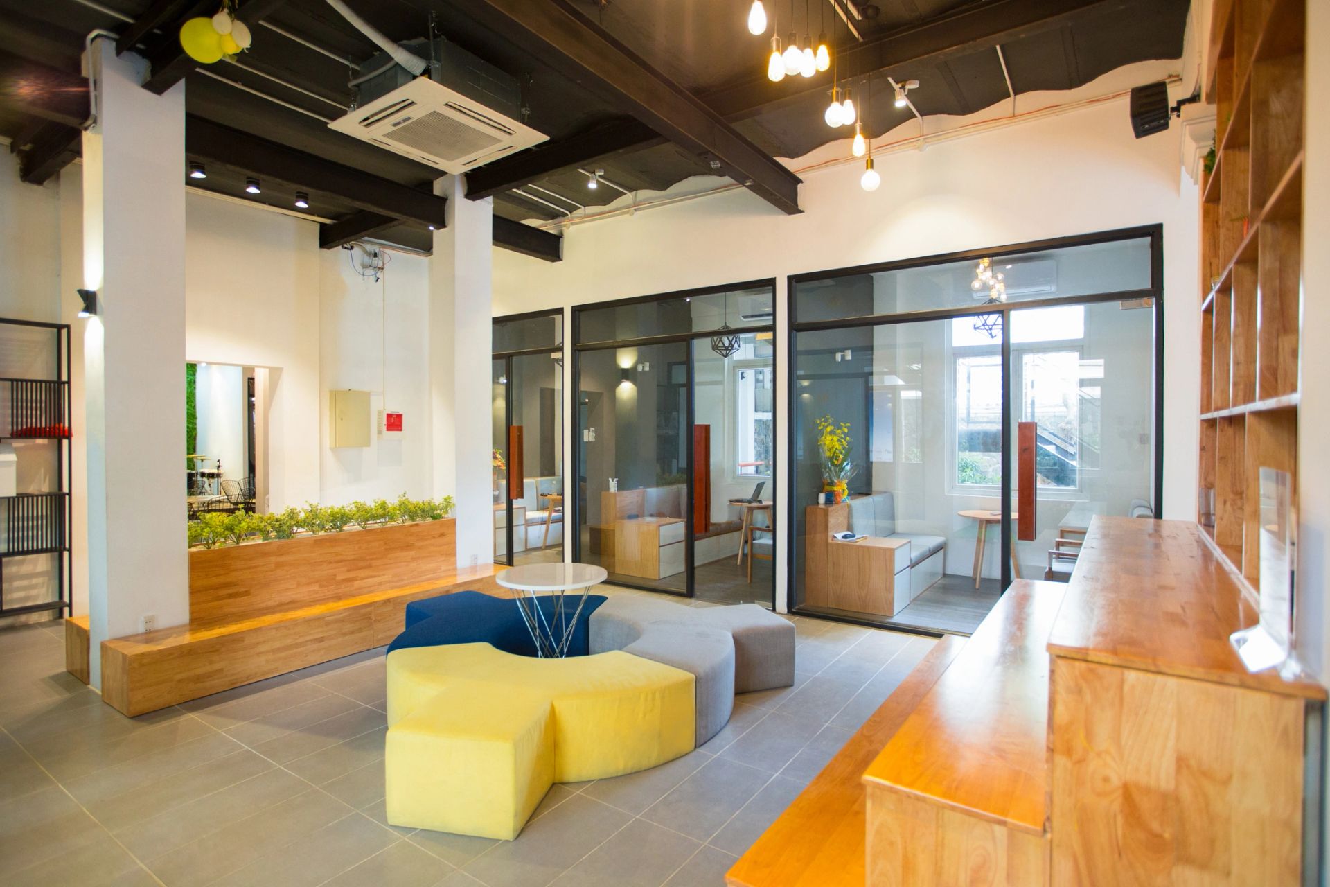 Modern lobby of business center with designers furniture in center of room. Wooden benches and shelves in room. Small rest rooms behind glassy walls. Office interior concept (Modern lobby of business center with designers furniture in center of room.